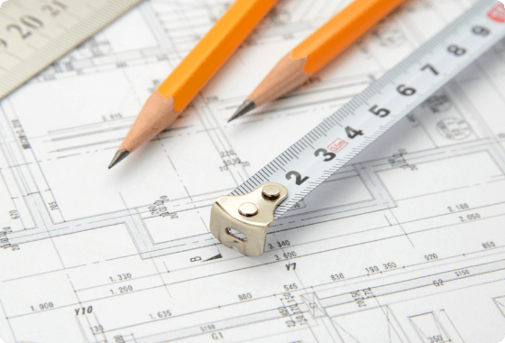 図面の上にある鉛筆とメジャー